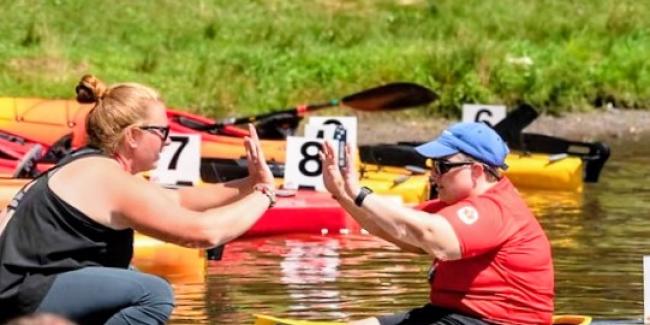 Kayaker and coach high-ten